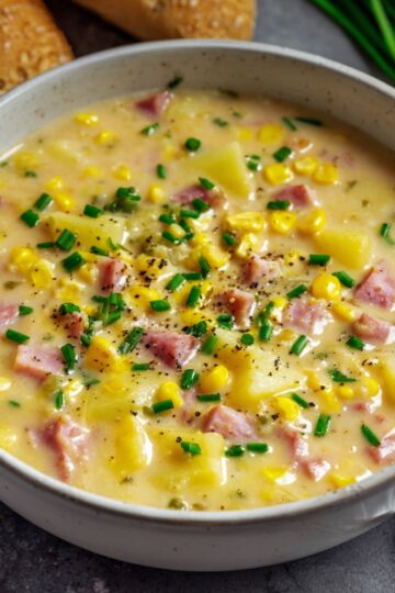 Healthy Ham and Potato Soup Recipe 3 Ham and Potato Soup A bowl of finished creamy ham, potato, and corn chowder garnished with chopped chives, ready to be served.