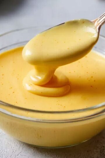 Easy Hollandaise Sauce Recipe 2 Hollandaise Sauce A rich and creamy hollandaise sauce in a glass bowl, with a spoon dripping some of the golden sauce.
