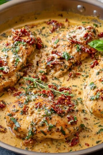 Delicious Marry Me Chicken Recipe 4 Marry Me Chicken A creamy skillet chicken dish with sun-dried tomatoes, garlic, and fresh herbs, simmering in a rich sauce, perfect for a romantic dinner. The golden-brown chicken breasts are coated with a creamy sauce, garnished with fresh basil and Parmesan, ready to be served. It’s a dish so flavorful, it’s sure to impress anyone.