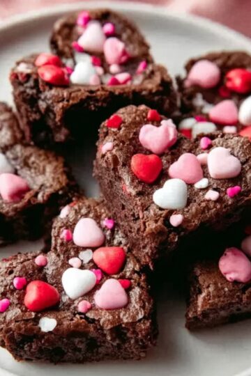 Healthy Heart Shaped Brownies Recipe 2 heart shaped brownies A plate of heart-shaped brownies decorated with pink, white, and red candy-coated chocolate pieces, arranged neatly for a festive display.