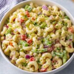 macaroni salad A vibrant bowl of macaroni salad, filled with fresh vegetables like red bell peppers, onions, and celery, all mixed with creamy dressing. This classic side dish is perfect for gatherings and picnics