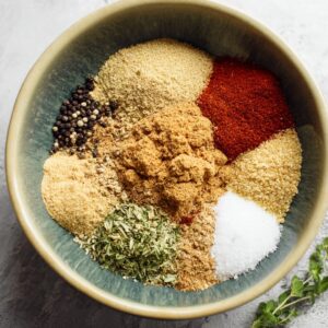 A bowl of spices and seasonings ready to be mixed for pork chop seasoning.