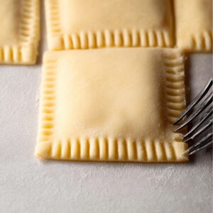 Healthy Blueberry Pop Tarts Recipe 16 A close-up of fork marks on the edges of pastry dough squares, ready to be sealed and baked into pop tarts.