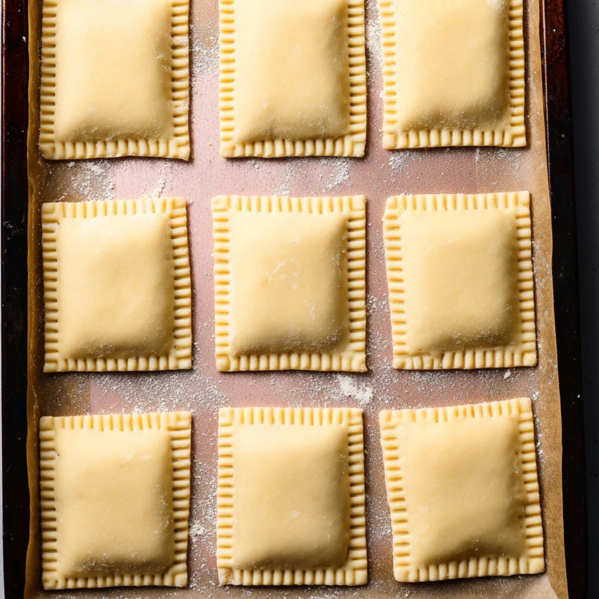 Healthy Blueberry Pop Tarts Recipe 12 A close-up of fork marks on the edges of pastry dough squares, ready to be sealed and baked into pop tarts.