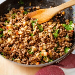 Easy Chicken Lettuce Wraps Recipe 16 A close-up of a skillet with ground meat, diced vegetables, and seasonings cooking together, creating a savory mixture for the chicken lettuce wraps.