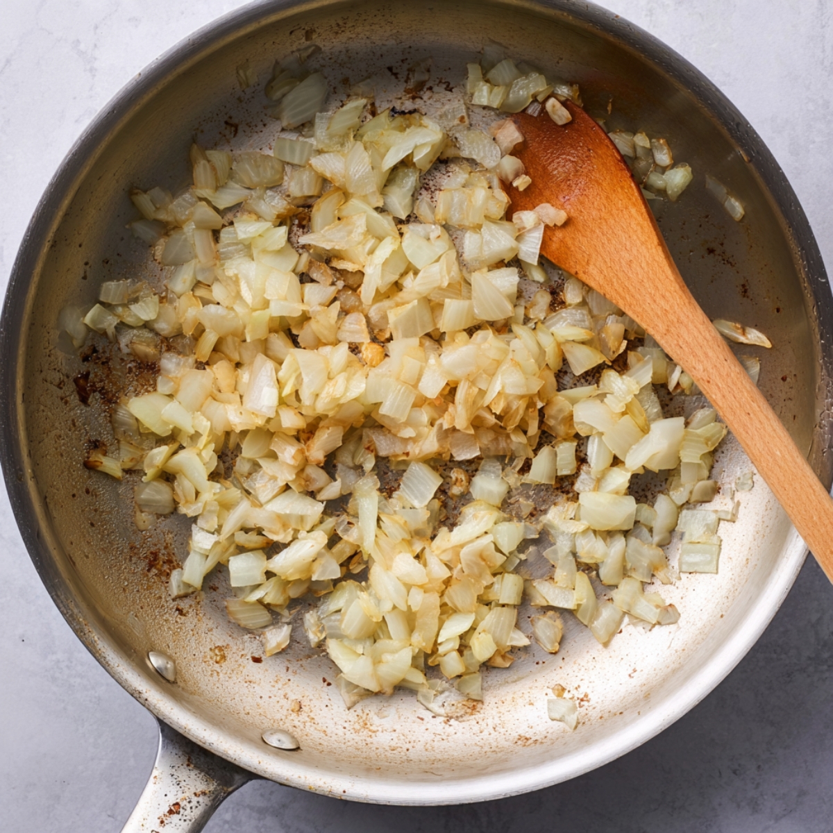 Easy Chicken Lettuce Wraps Recipe 10 Sliced mushrooms being sautéed in a skillet, with a wooden spoon stirring them as they release moisture and cook down.