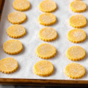 Best Chocolate Orange Sandwich Cookies 16 A baking sheet lined with orange butter cookie dough rounds, sprinkled with sugar before baking.