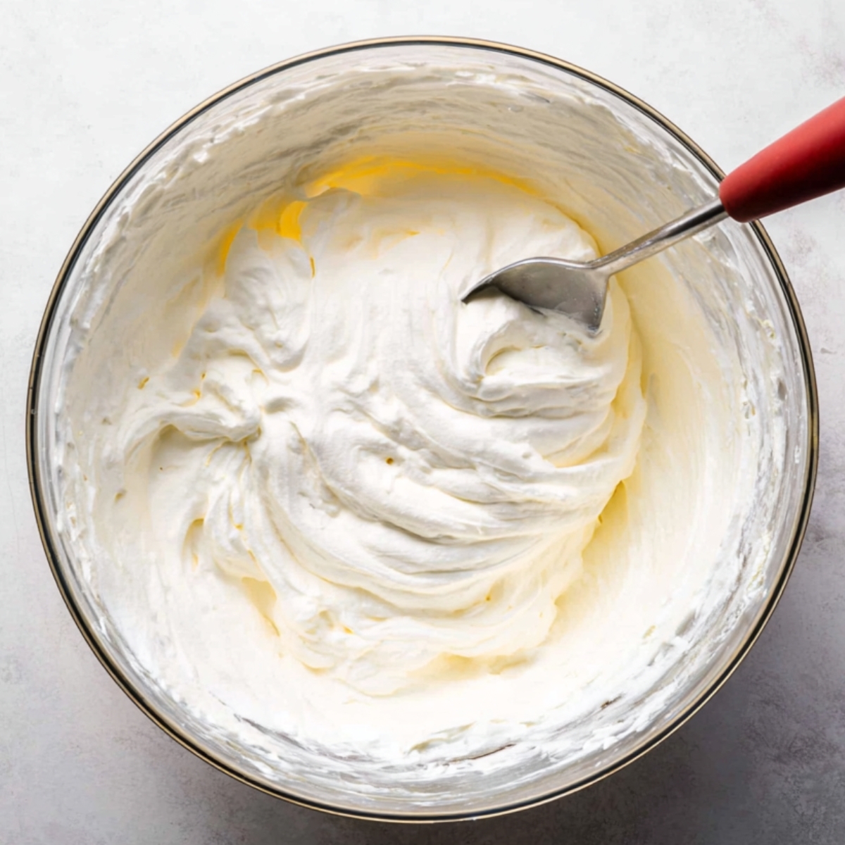 Easy Cookies and Cream Pie Recipe 11 A mixing bowl containing perfectly whipped cream peaks, the fluffy texture ready to be folded into a dessert or used as a topping.