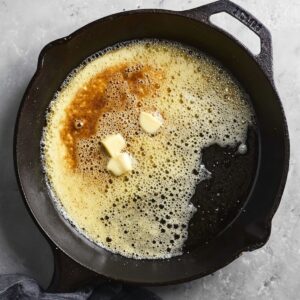 Butter melting in a hot skillet, beginning to sizzle