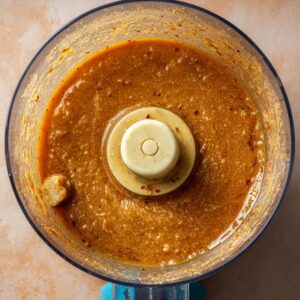 Best Homemade Ginger Dressing Recipe 14 A food processor containing a blended ginger dressing, showing a smooth, rich mixture of ginger, soy sauce, and other seasonings.