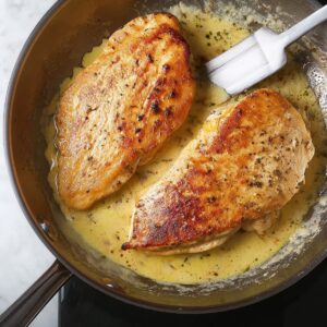 The chicken breasts are seared to perfection, developing a golden-brown crust that will enhance the flavor and texture. This crucial step locks in moisture, ensuring the chicken remains juicy as it simmers in the rich, creamy sauce