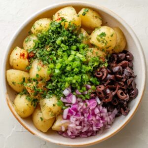 Easy Mediterranean Potato Salad Recipe 16 A close-up of fresh salmon fillets seasoned with herbs and lemon, ready for grilling. The salmon is perfectly marinated, with glistening skin and vibrant color, offering a healthy and flavorful meal option.