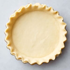 The Best Quiche Lorraine Recipe 15 Trimming the edges of a pie crust with scissors for a neat and polished appearance.
