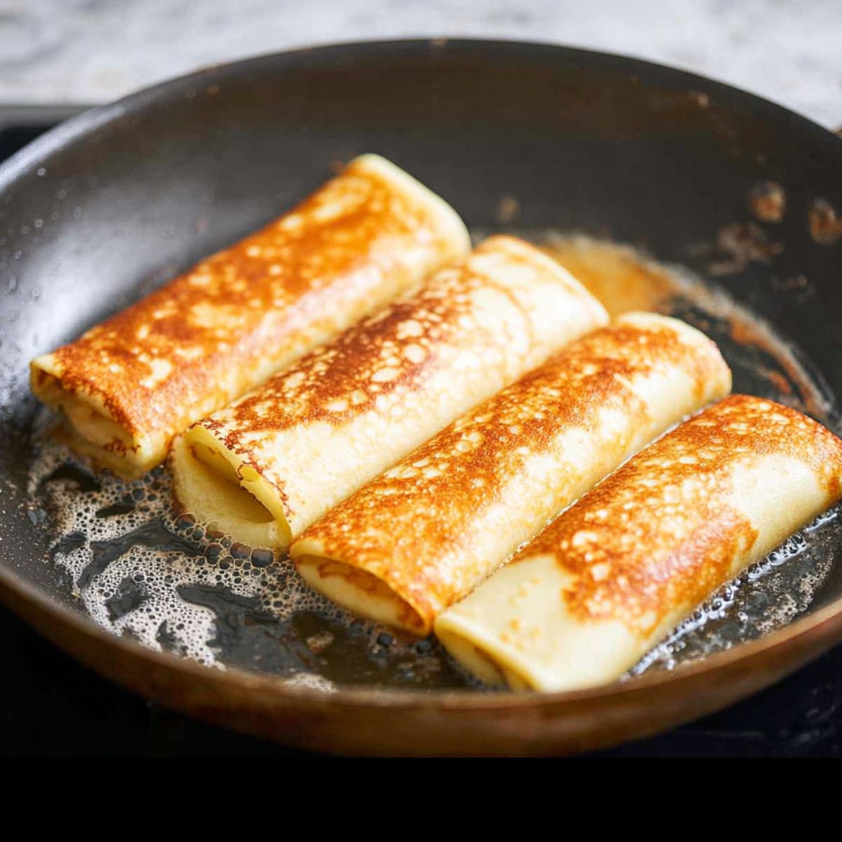 Healthy Homemade Blintzes Recipe 12 A delicious serving of blintzes, filled with a sweet or savory mixture, dusted with powdered sugar, and resting on a plate with berry sauce underneath.