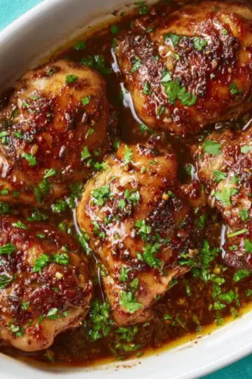Best Balsamic Chicken Thighs Recipe 2 Balsamic Chicken Thighs A white oval baking dish with baked balsamic chicken thighs, richly glazed and garnished with fresh parsley, golden-brown skin, juicy meat, ready to serve, close-up, overhead angle.
