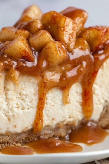 The Best Caramel Apple Cheesecake Recipe 4 Caramel Apple Cheesecake Close-up of a slice of creamy caramel apple cheesecake on a plate, topped with tender cinnamon apple chunks and glossy caramel sauce, showing the smooth texture and golden crust.