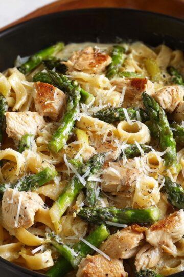 Healthy Chicken Asparagus Pasta Recipe 1 Chicken Asparagus Pasta Finished dish of chicken and asparagus pasta in a creamy sauce, garnished with grated cheese and ready to serve.