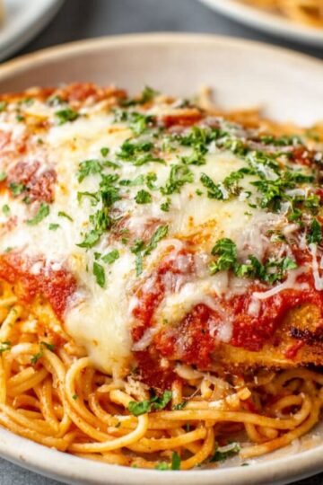 Easy Chicken Parmesan with Spaghetti Recipe 1 Chicken Parmesan with Spaghetti A plated serving of chicken parmesan over spaghetti, topped with marinara sauce, melted mozzarella, and a sprinkle of chopped parsley.