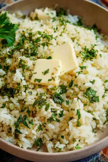 Healthy Garlic Butter Rice Recipe 2 Garlic Butter Rice The finished garlic butter rice, garnished with fresh parsley and a pat of butter on top.