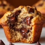 chocolate chunk banana muffins A close-up of a warm muffin, with gooey chocolate chunks inside.