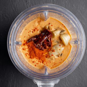 Best Black Bean Burritos Recipe 17 A blender filled with creamy, smooth sauce made from a blend of ingredients, with a rich, orange hue and hints of smoky flavors, ready to complement any dish.