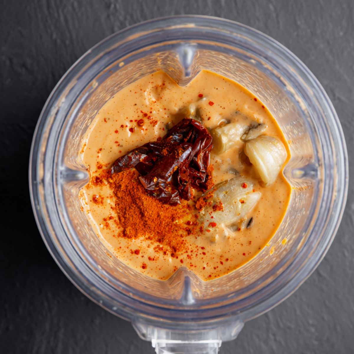 Best Black Bean Burritos Recipe 12 A blender filled with creamy, smooth sauce made from a blend of ingredients, with a rich, orange hue and hints of smoky flavors, ready to complement any dish.