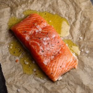 The Best Creamy Salmon Pasta Recipe 14 Fresh salmon fillet seasoned with salt, pepper, and olive oil placed on parchment paper before cooking.