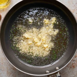 Healthy Garlic Butter Rice Recipe 15 Garlic and butter being sautéed together in the pan, with other ingredients prepared for the rice dish.