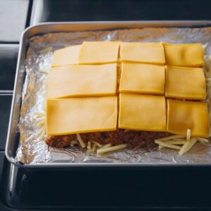 Easy Homemade Sliders Recipe 17 A layer of cheese slices is placed over the cooked meat, which will melt into a gooey topping.