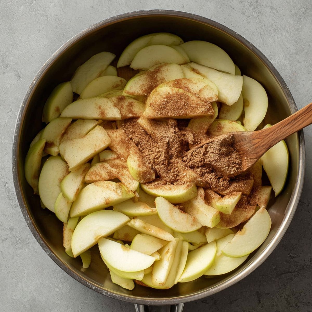 Best Baked Apple Oatmeal Recipe 10 A pan of thinly sliced apples seasoned with cinnamon and sugar, ready to be combined with the oat mixture.