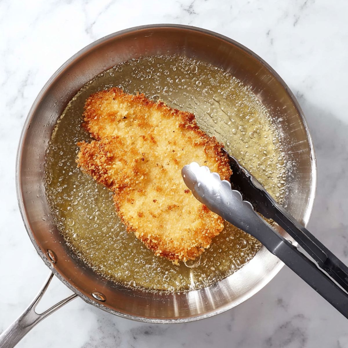 Delicious Chicken Schnitzel Recipe 12 Raw chicken breasts are seasoned and being dipped into egg wash and a breadcrumb mixture, ready to be coated.