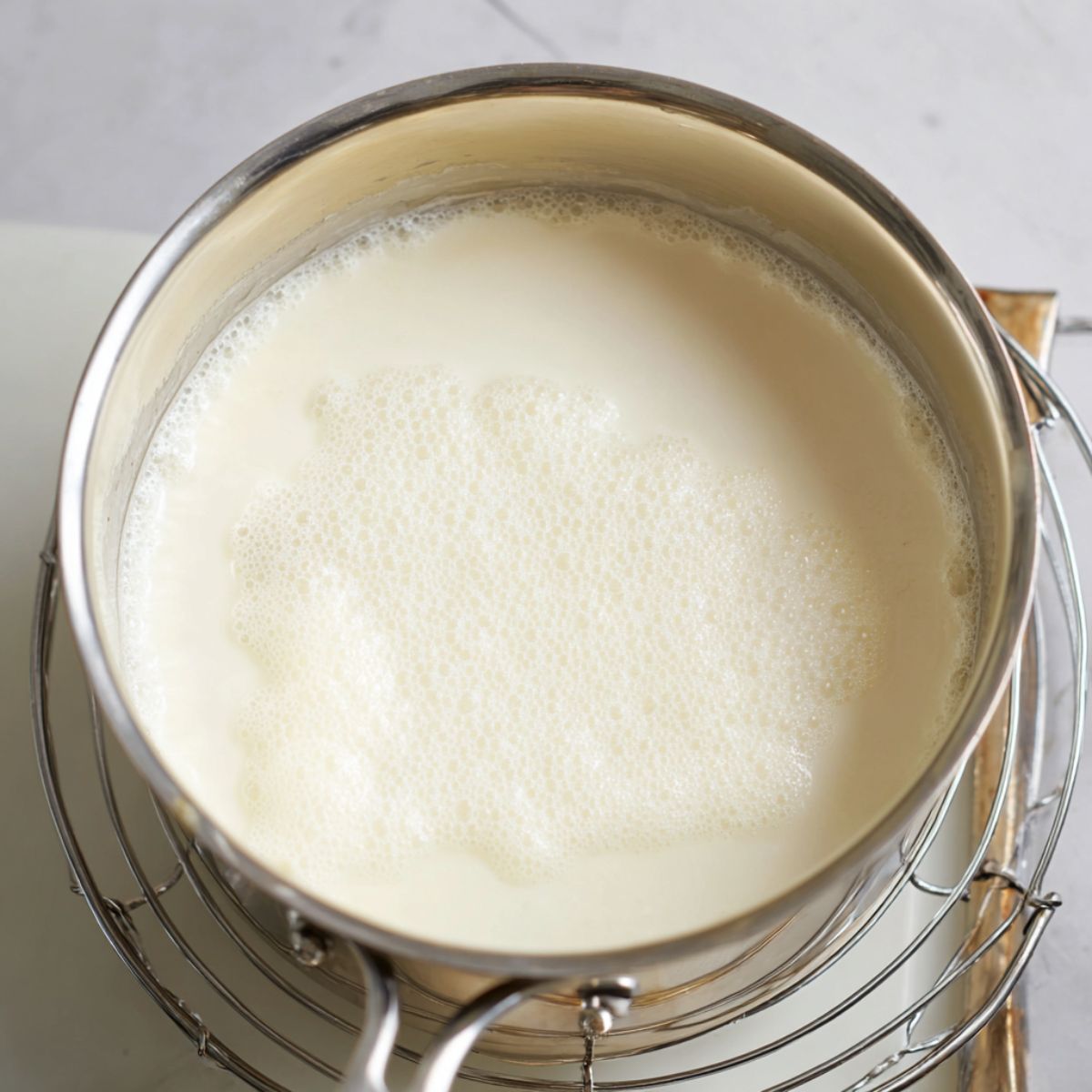 Delicious Creamy Grits Recipe 10 A top-down view of a pot of creamy grits just cooked, showing a slightly foamy surface and uniform texture.