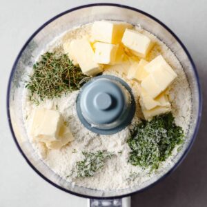 The Best Potato Galette Recipe 15 Food processor with cubes of butter, flour, and fresh herbs for the pastry crust.