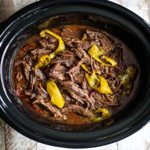 Best Mississippi Pot Roast Recipe 16 Shredded Mississippi pot roast in a slow cooker with pepperoncini peppers and rich cooking juices.