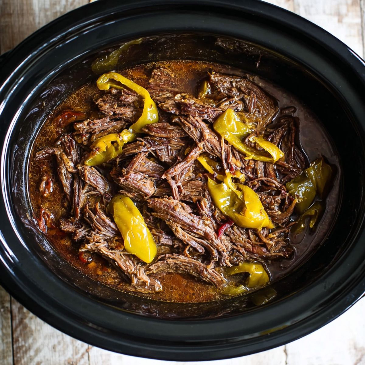Best Mississippi Pot Roast Recipe 12 Shredded Mississippi pot roast in a slow cooker with pepperoncini peppers and rich cooking juices.